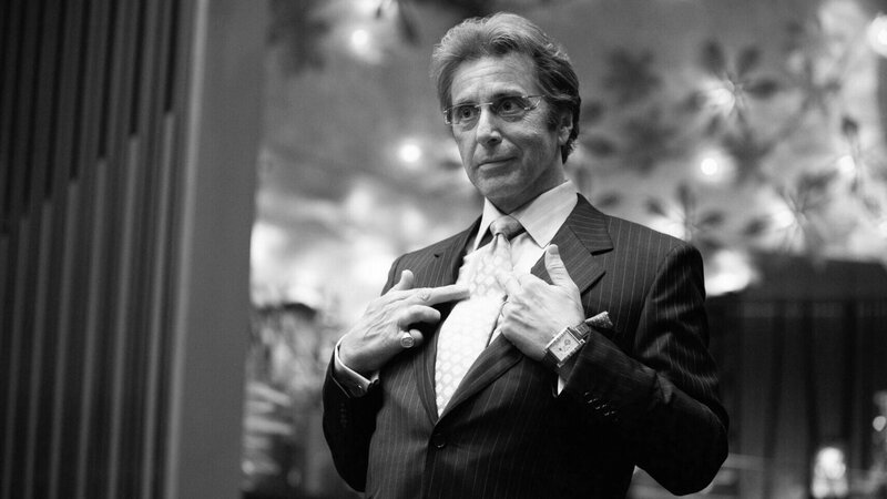 man in pinstripe suit adjusting tie