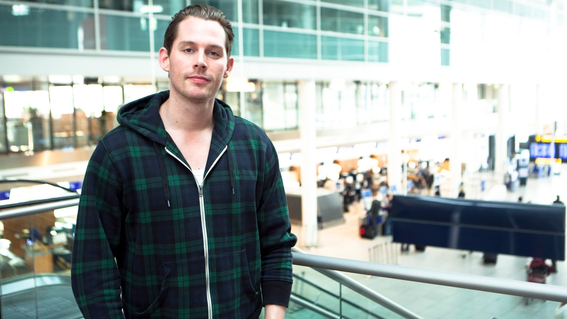 man in plaid hoodie at airport