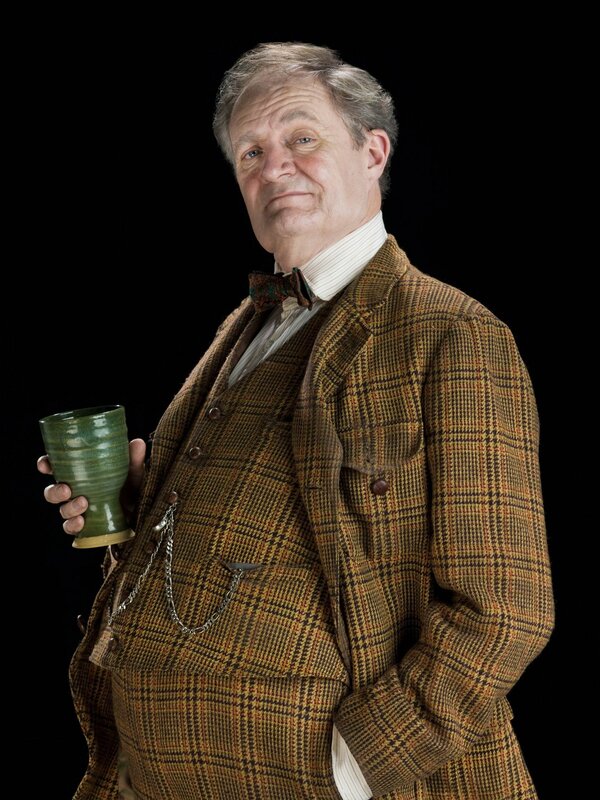 Man in plaid suit holding green cup