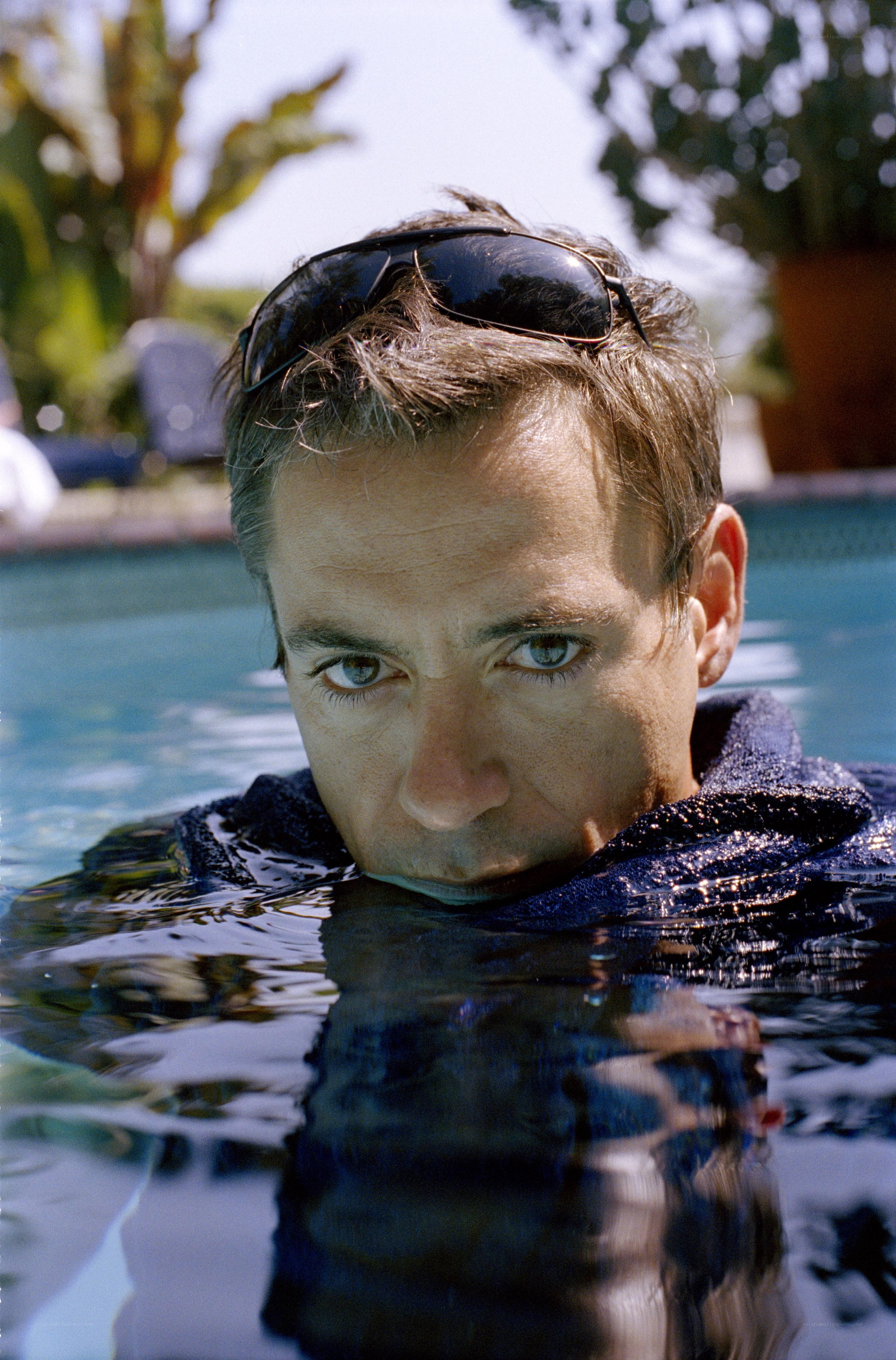 man in pool with sunglasses