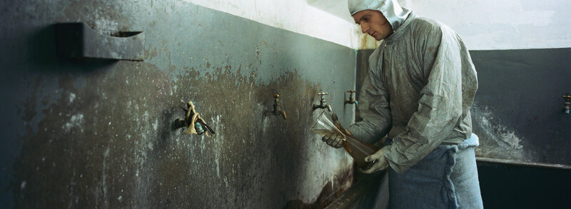 man in protective suit at sink