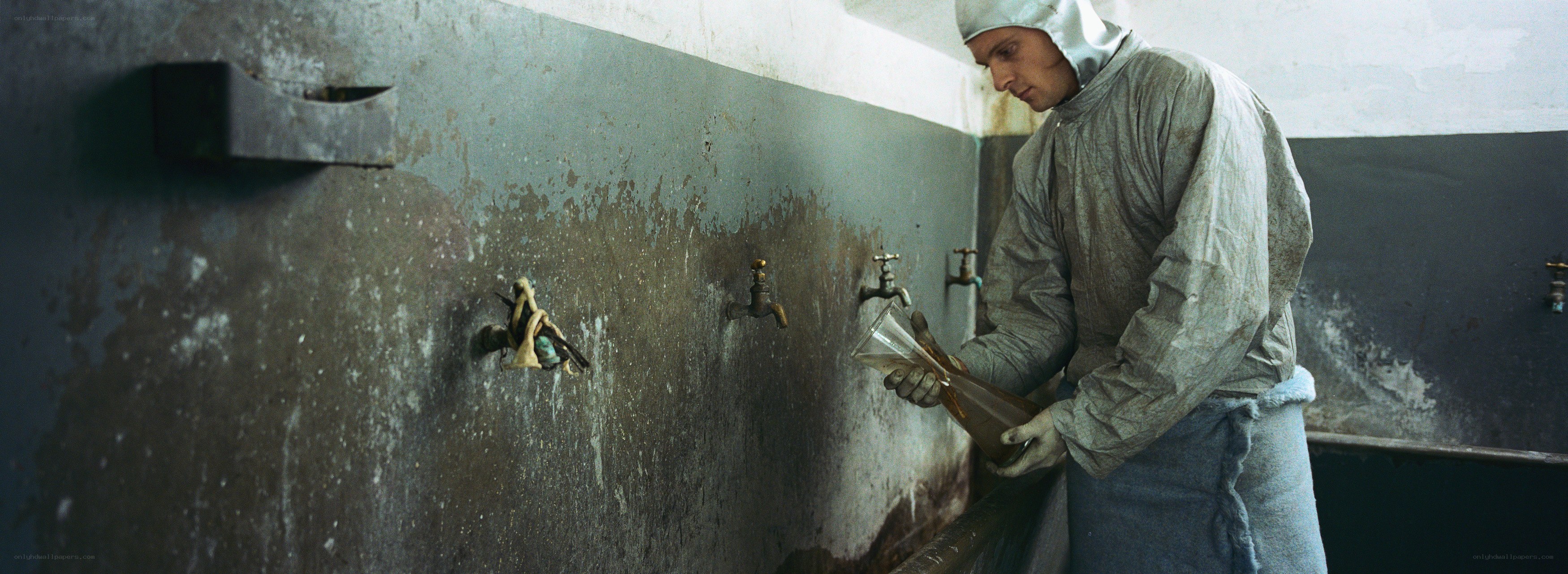 man in protective suit at sink