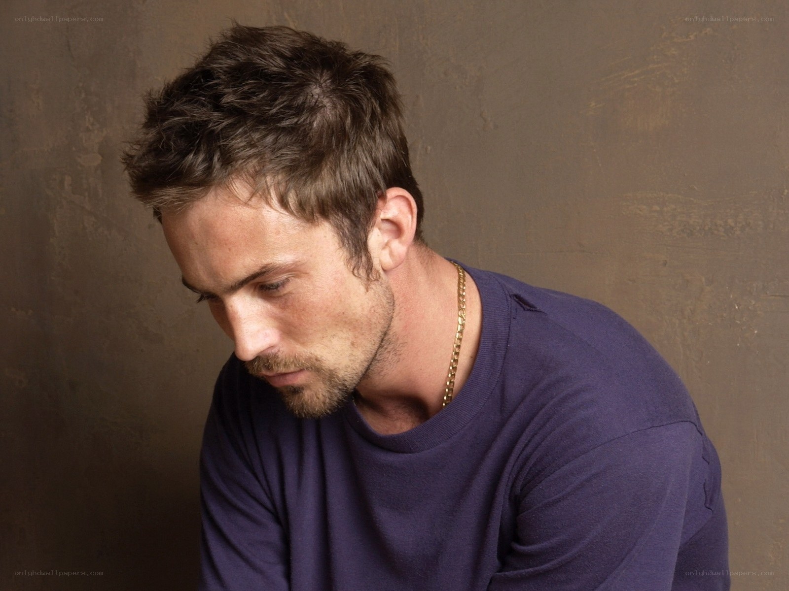 man in purple shirt looking down