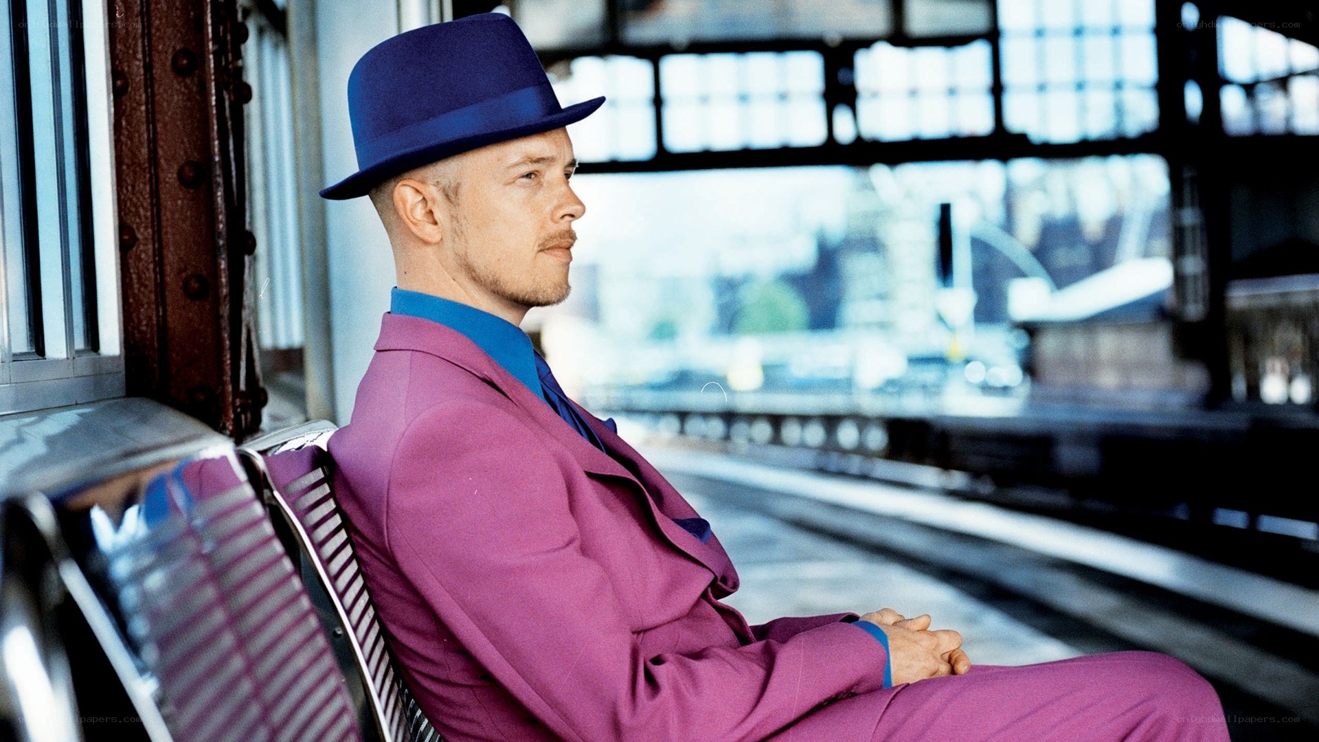 Man in purple suit at train station