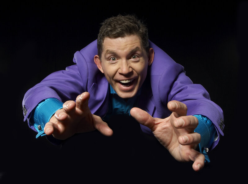man in purple suit reaching forward