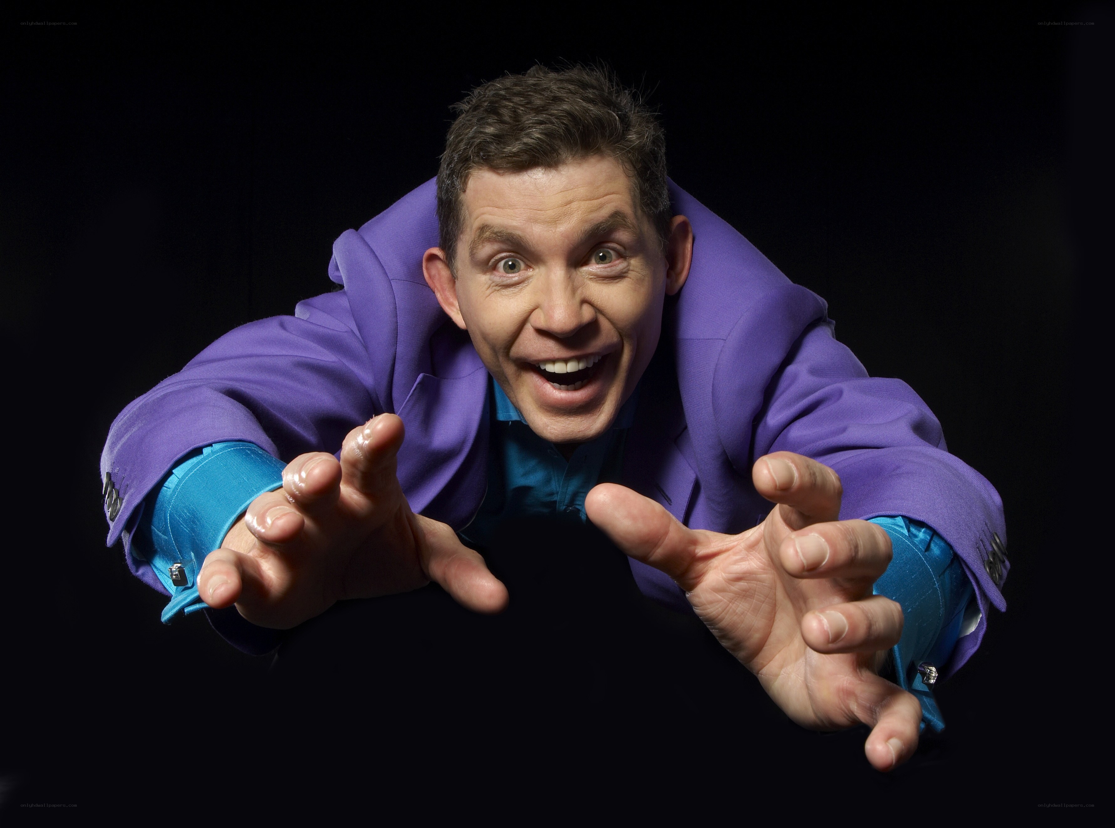 man in purple suit reaching forward