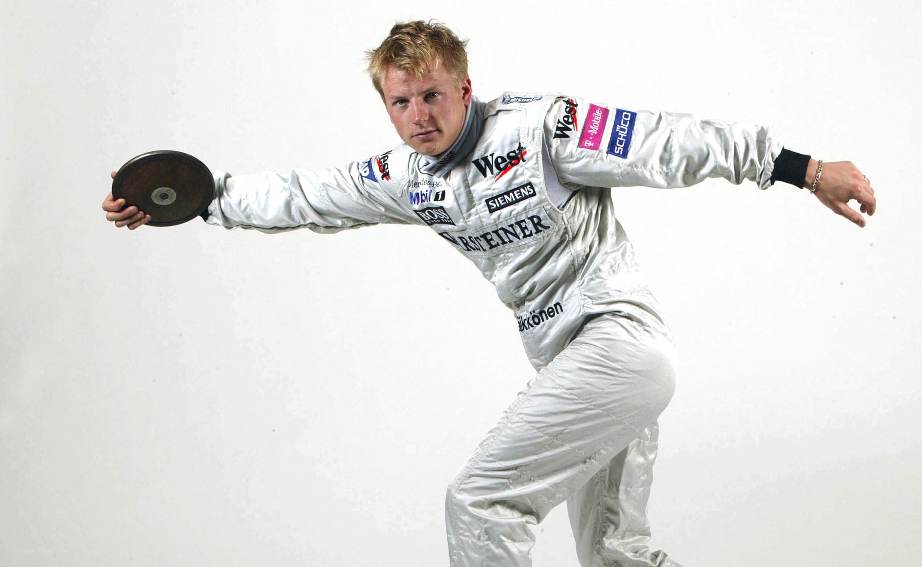 man in racing suit holding discus