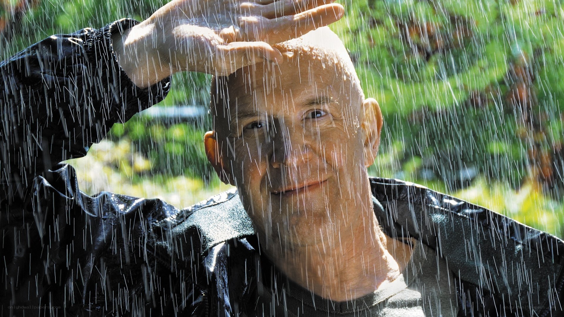man in rain with hand on head