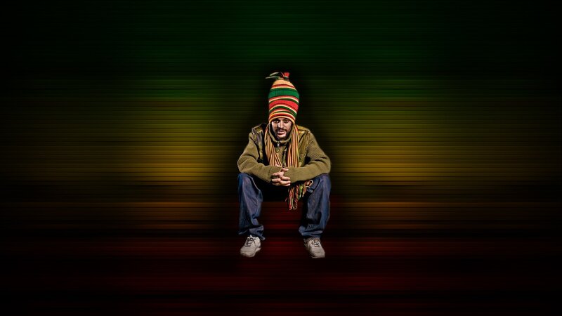 man in rasta hat sitting