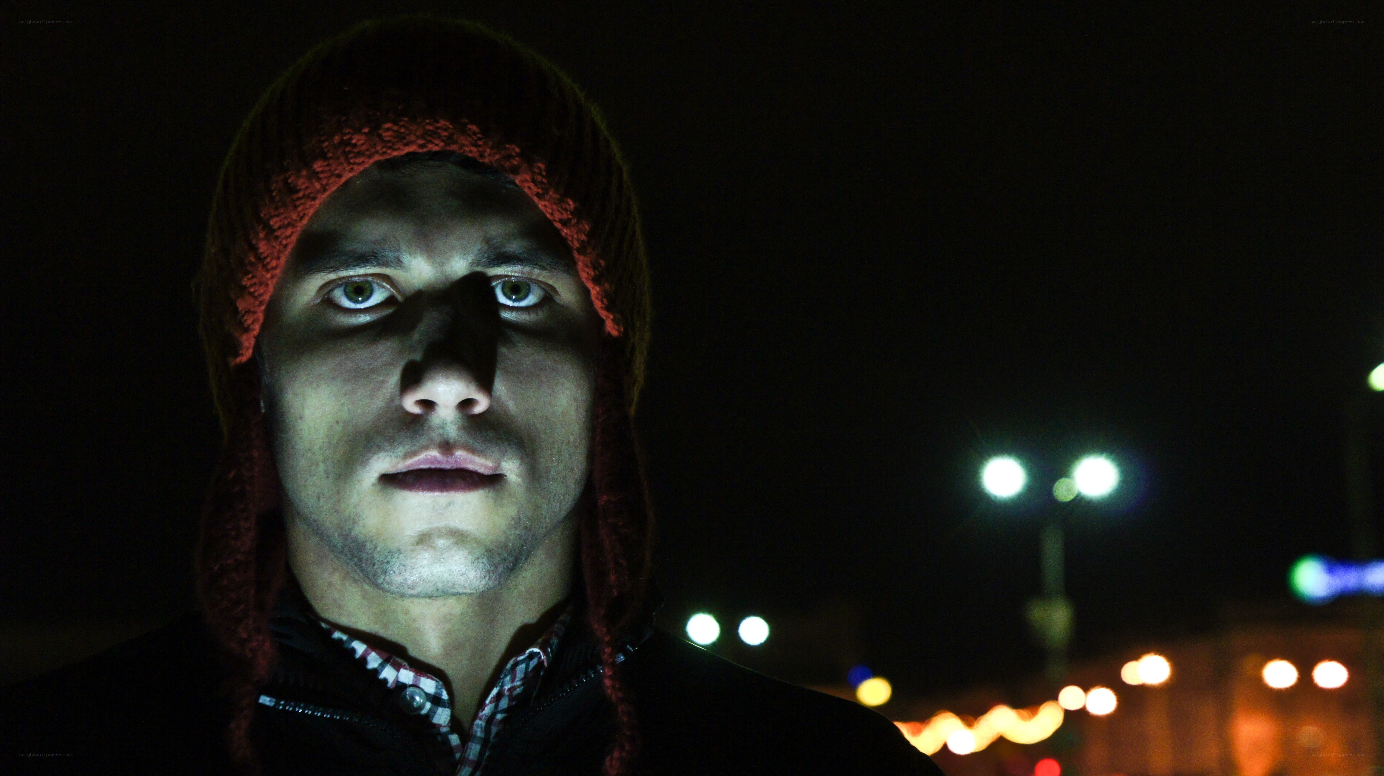 man in red beanie at night
