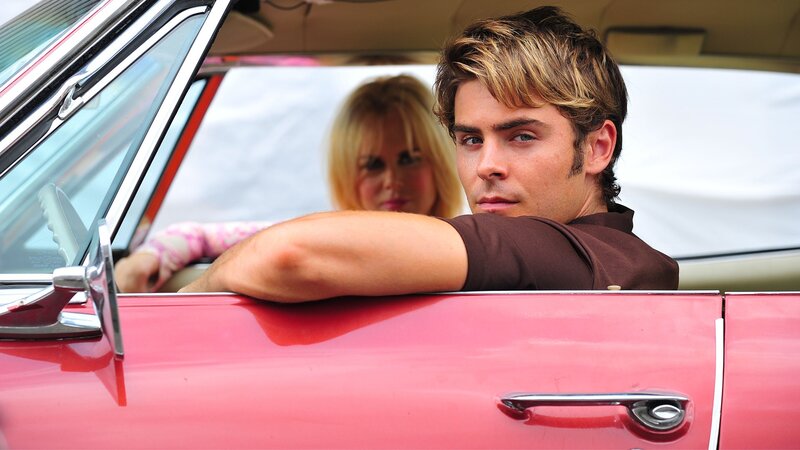 Man in red car with woman
