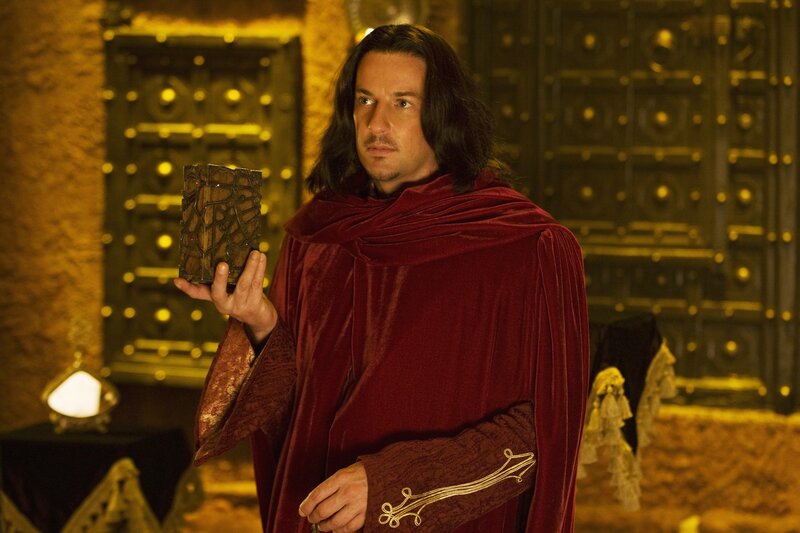 Man in red cloak holding artifact