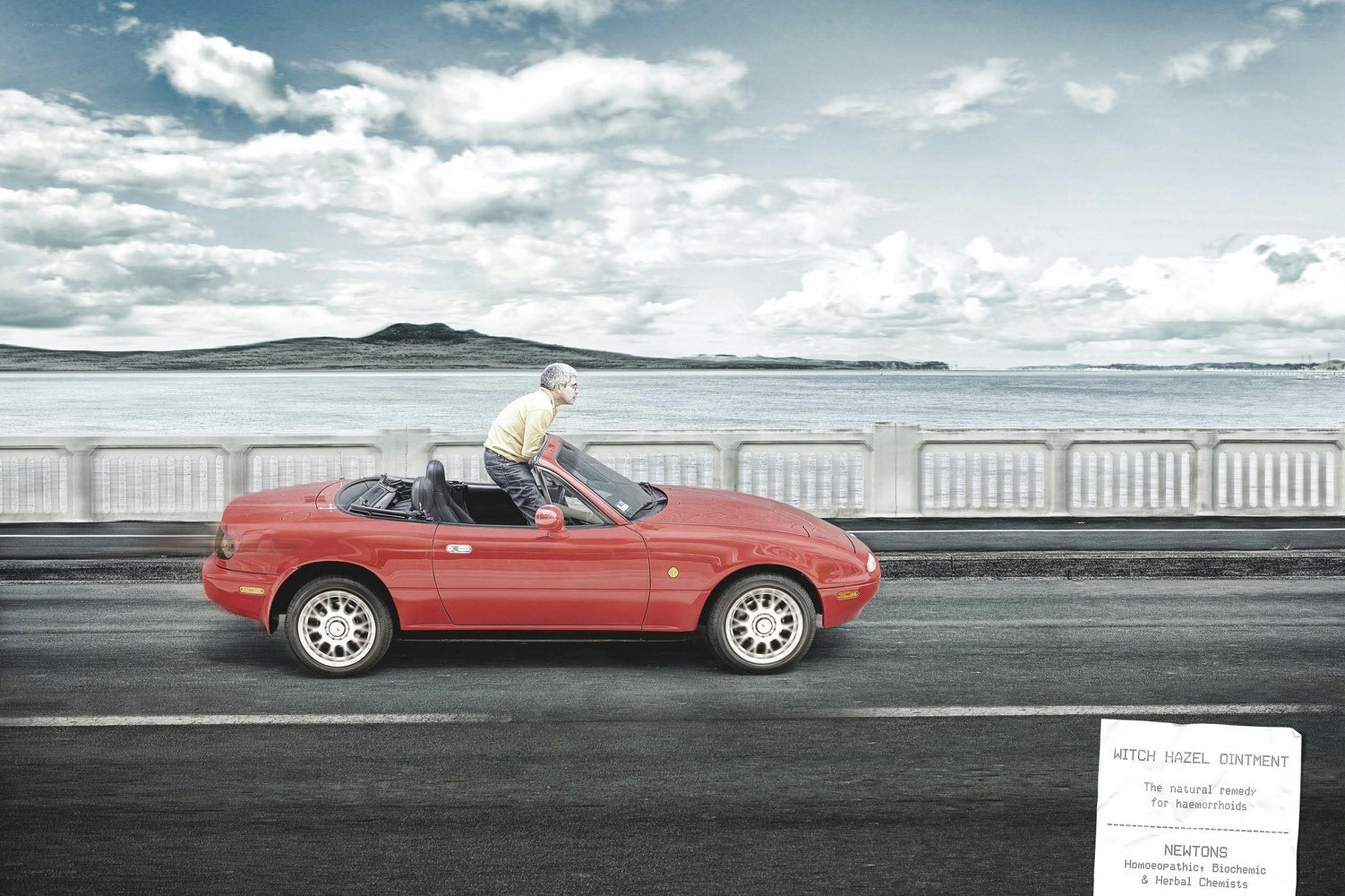 Man in red convertible car
