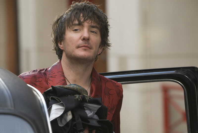 man in red shirt holding clothes