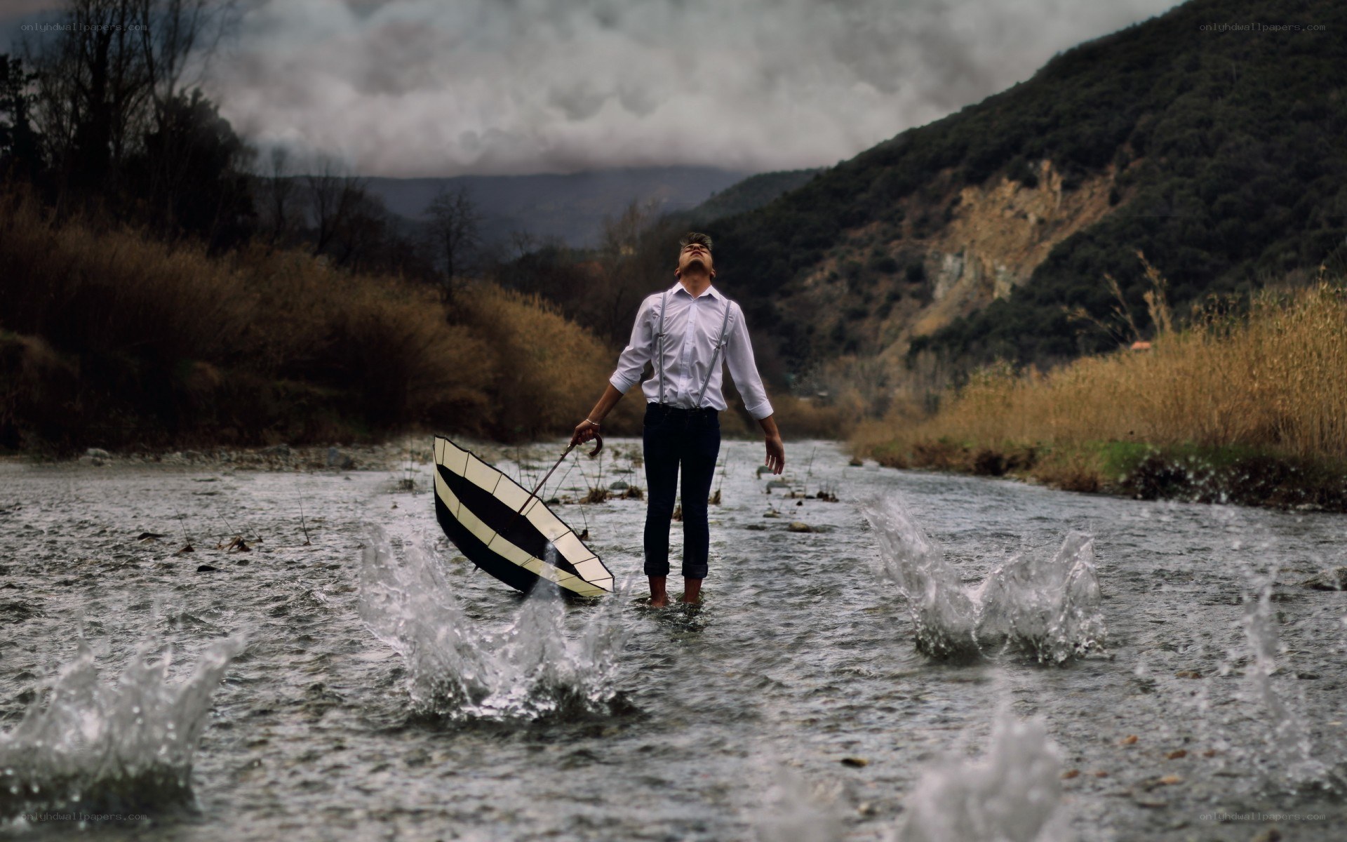 Man in river with umbrella