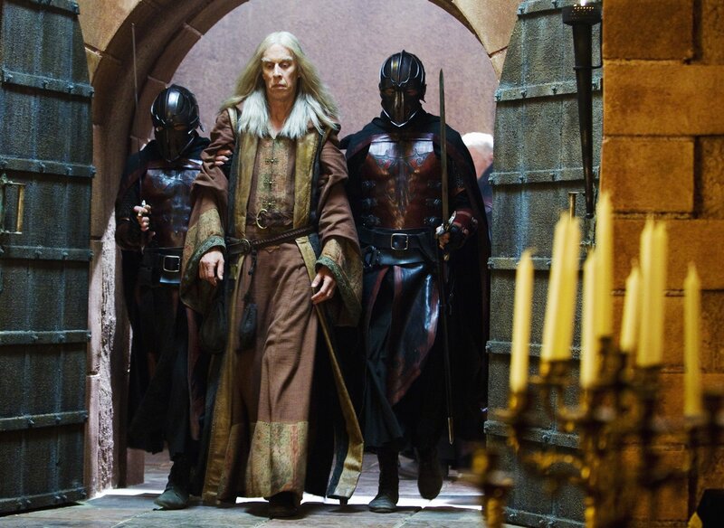 man in robes escorted by guards