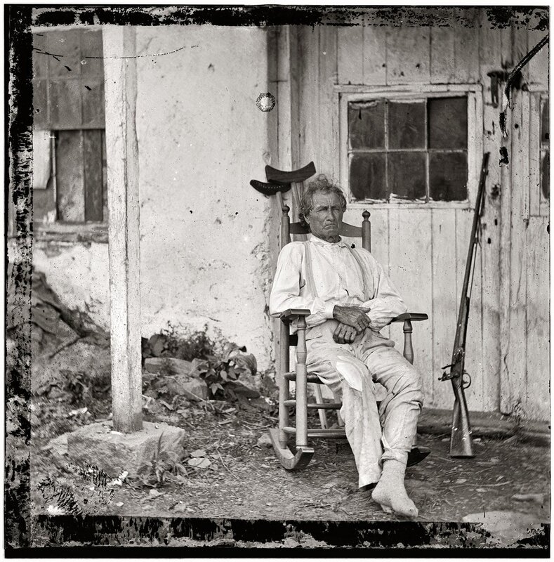 Man in rocking chair with rifle