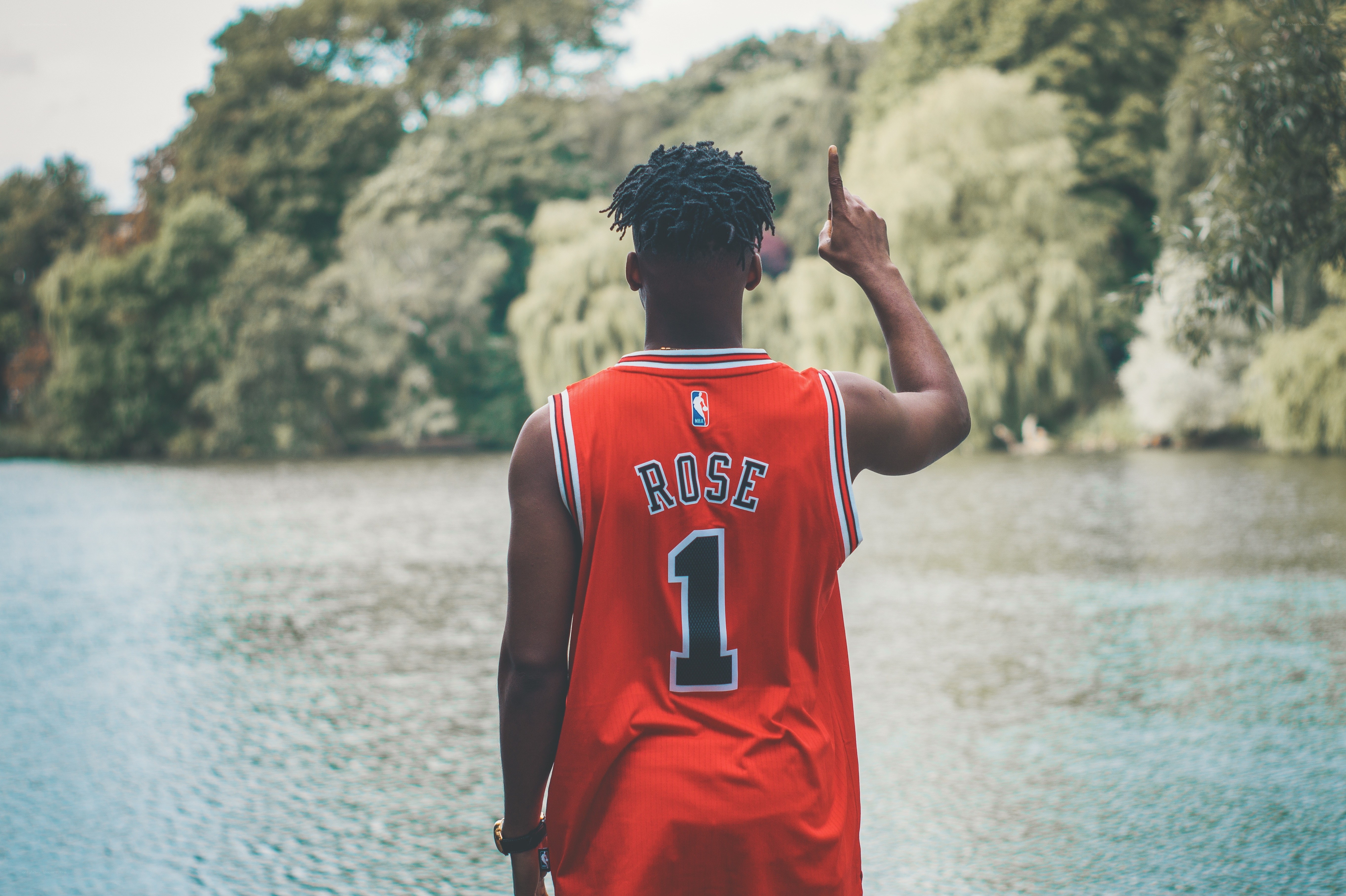 man in rose jersey by lake