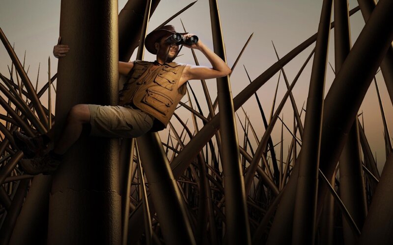 man in safari gear with binoculars