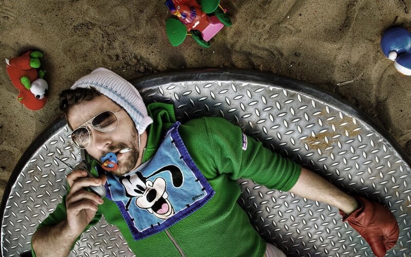 Man in sandbox with baby items