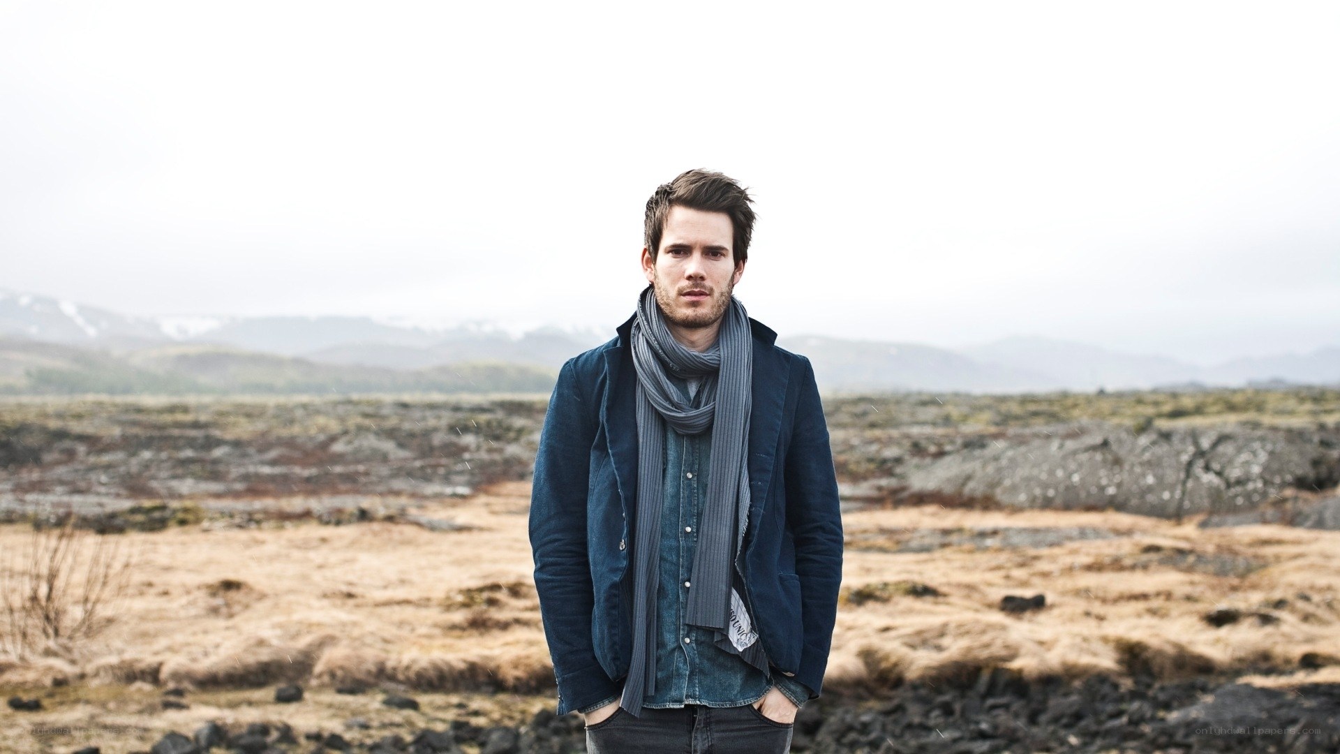 man in scarf on rocky landscape