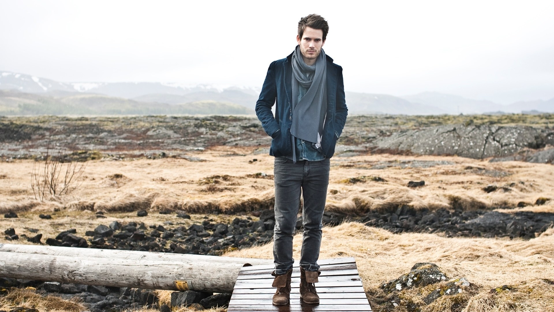 Man in scarf on wooden bridge