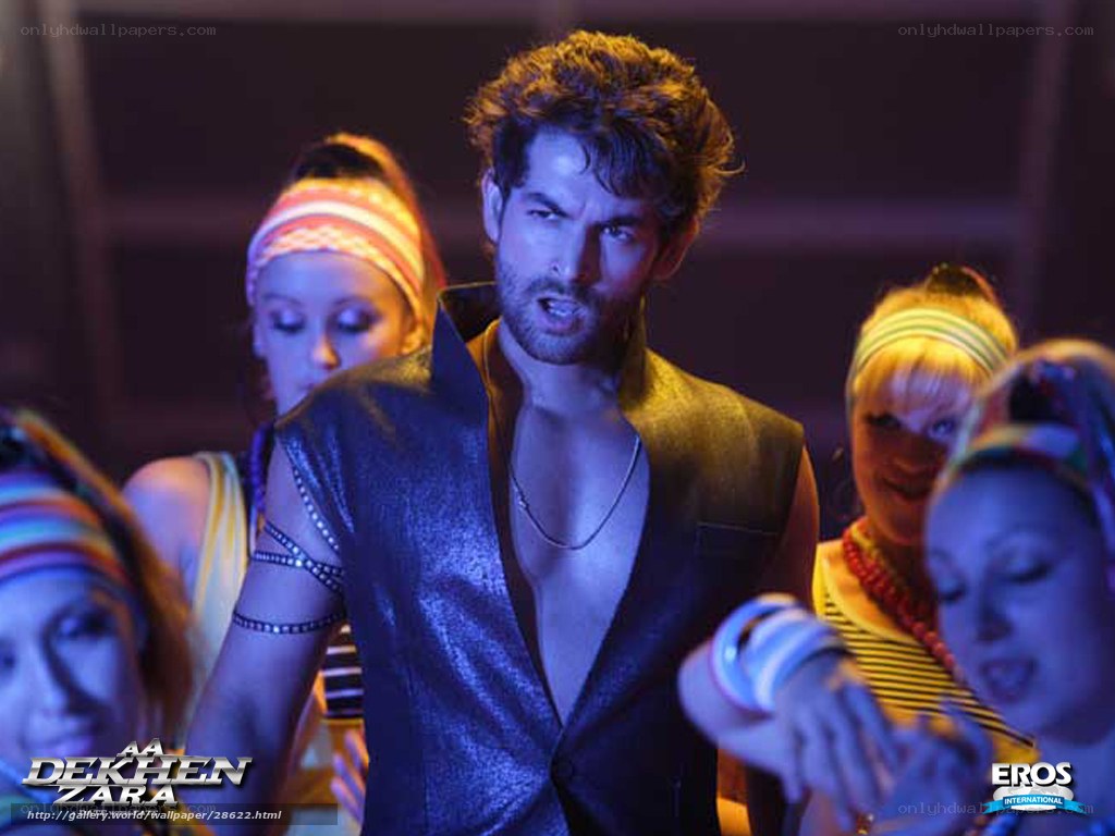 Man in shiny vest with dancers