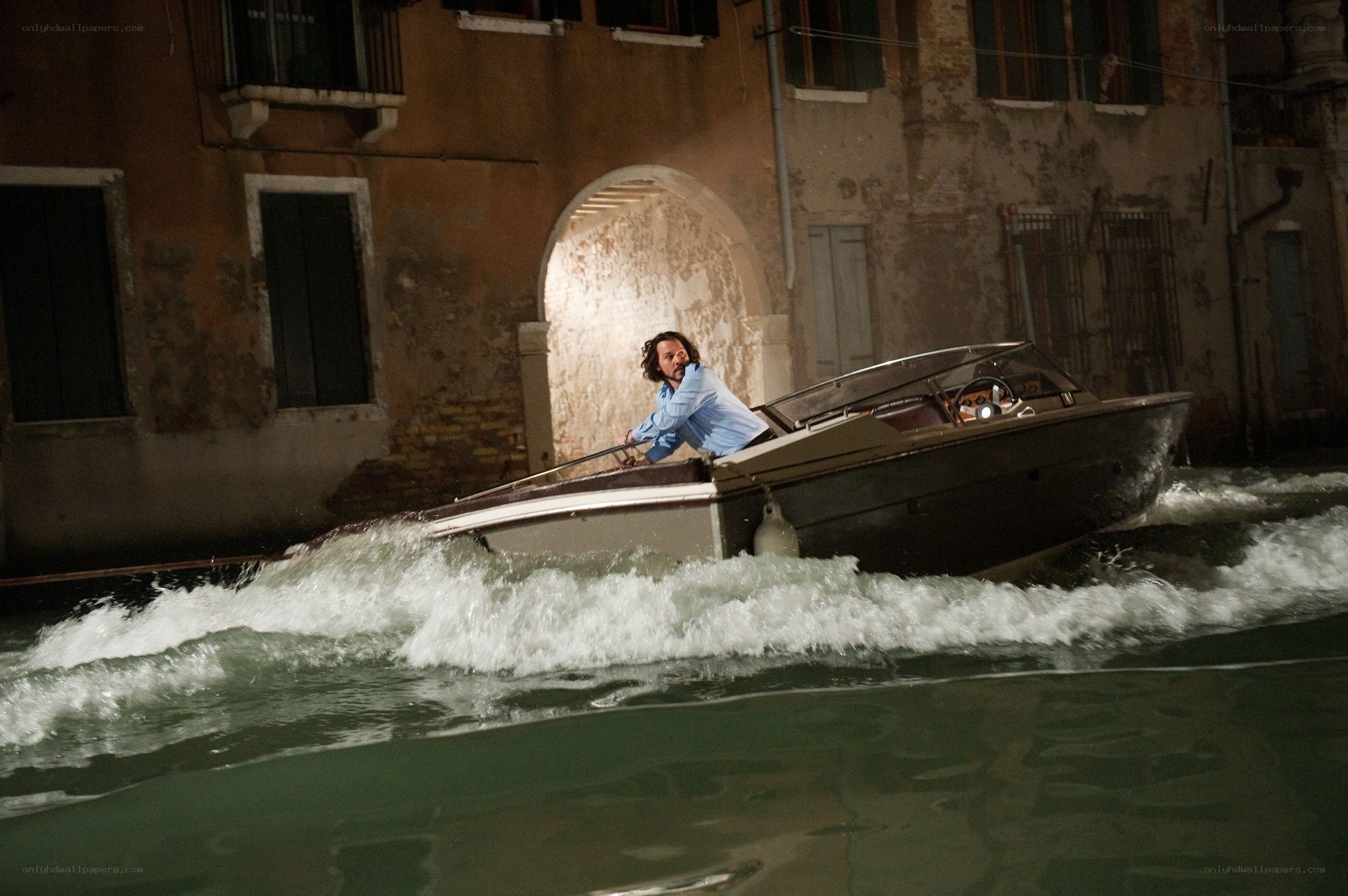 Man in speedboat at night