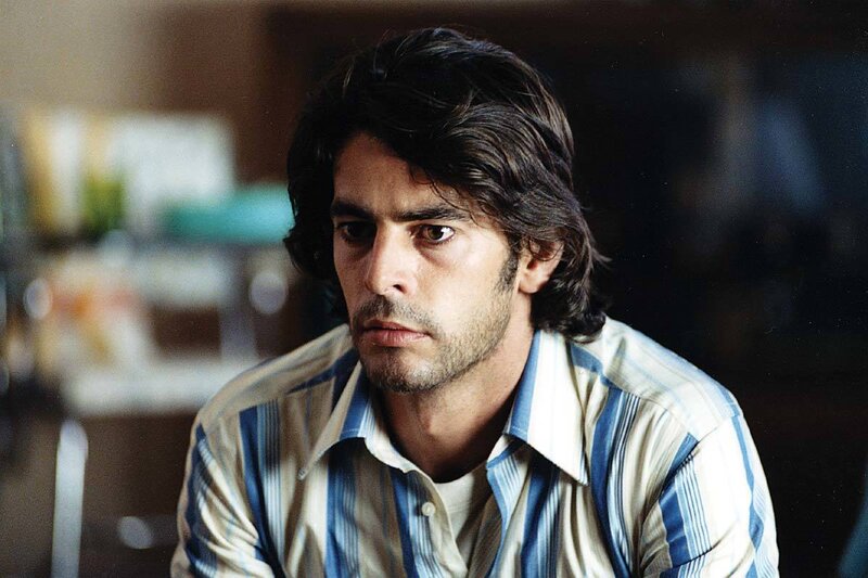 man in striped shirt looking down