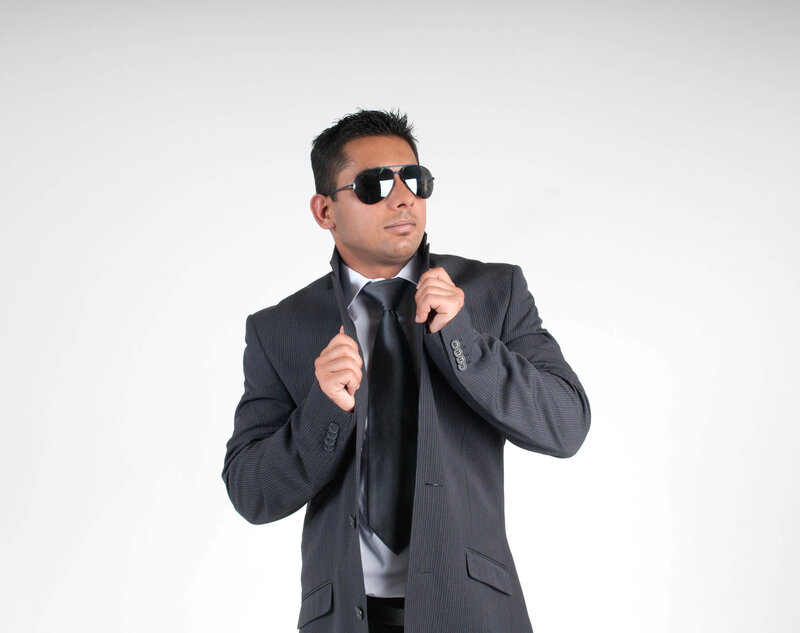Man in Suit Adjusting Tie — Gray