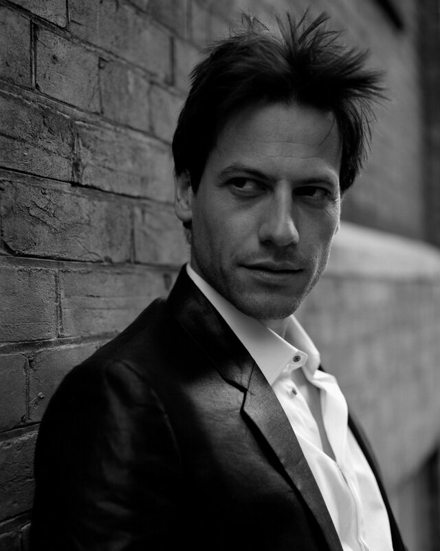 Man in Suit Against Brick Wall — Black, Serious