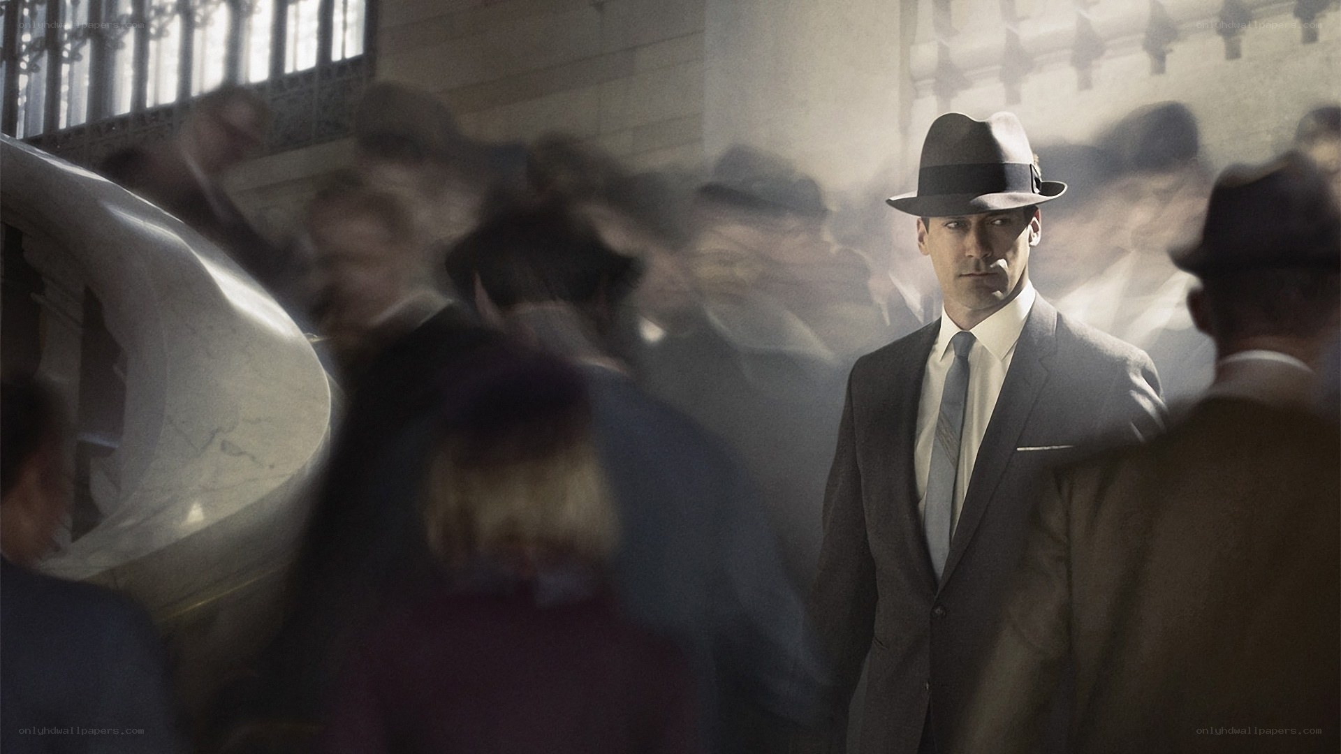 Man in suit and hat in crowd