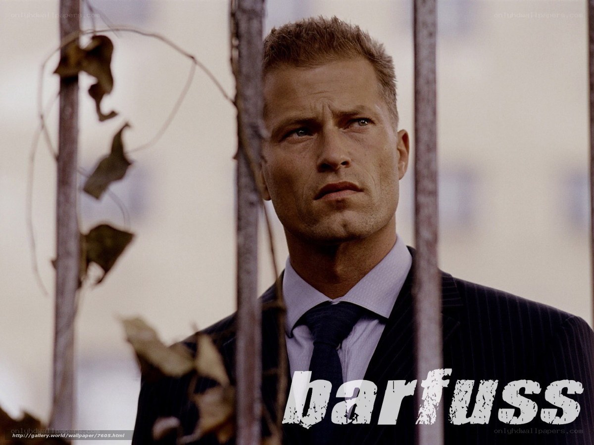 man in suit behind bars
