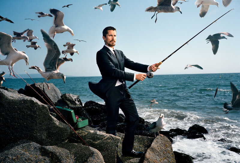 Man in suit fishing on rocks