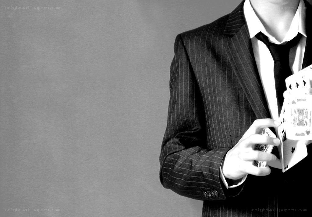 man in suit holding cards
