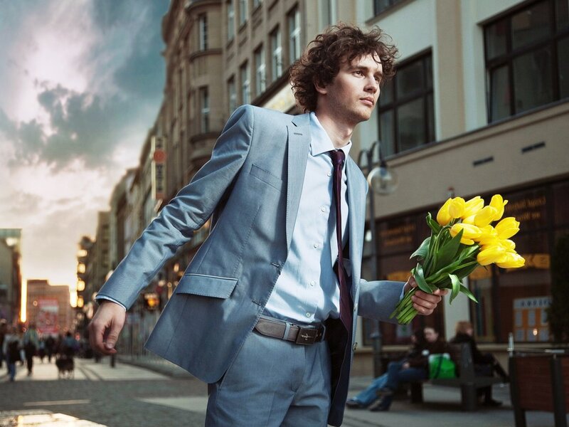 Man in Suit Holding Flowers