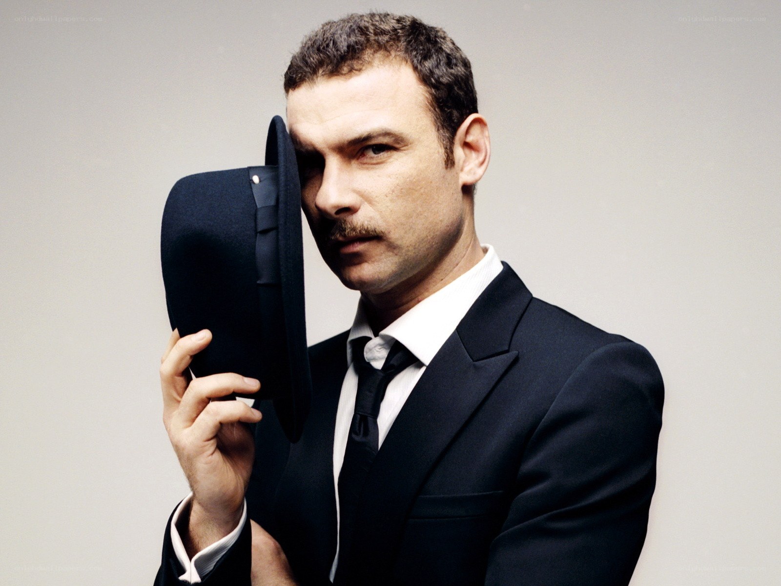 man in suit holding hat