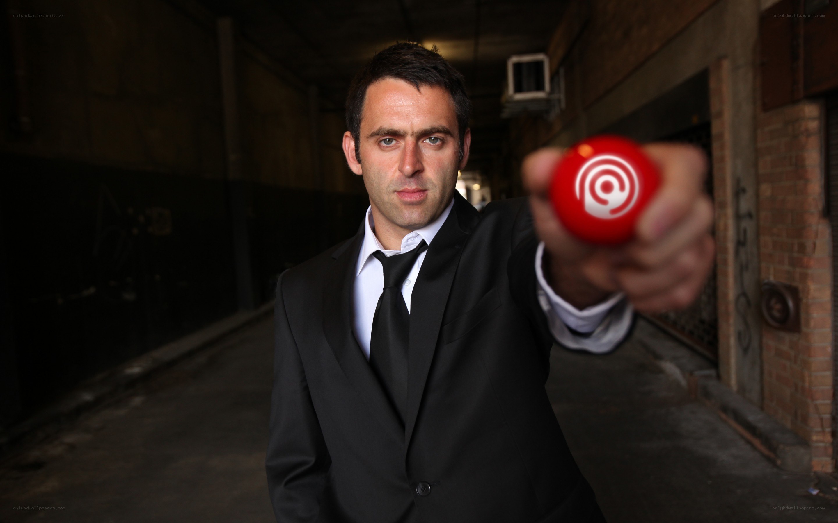 Man in suit holding red ball