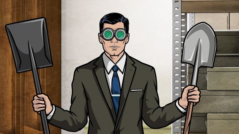 Man in suit holding shovels