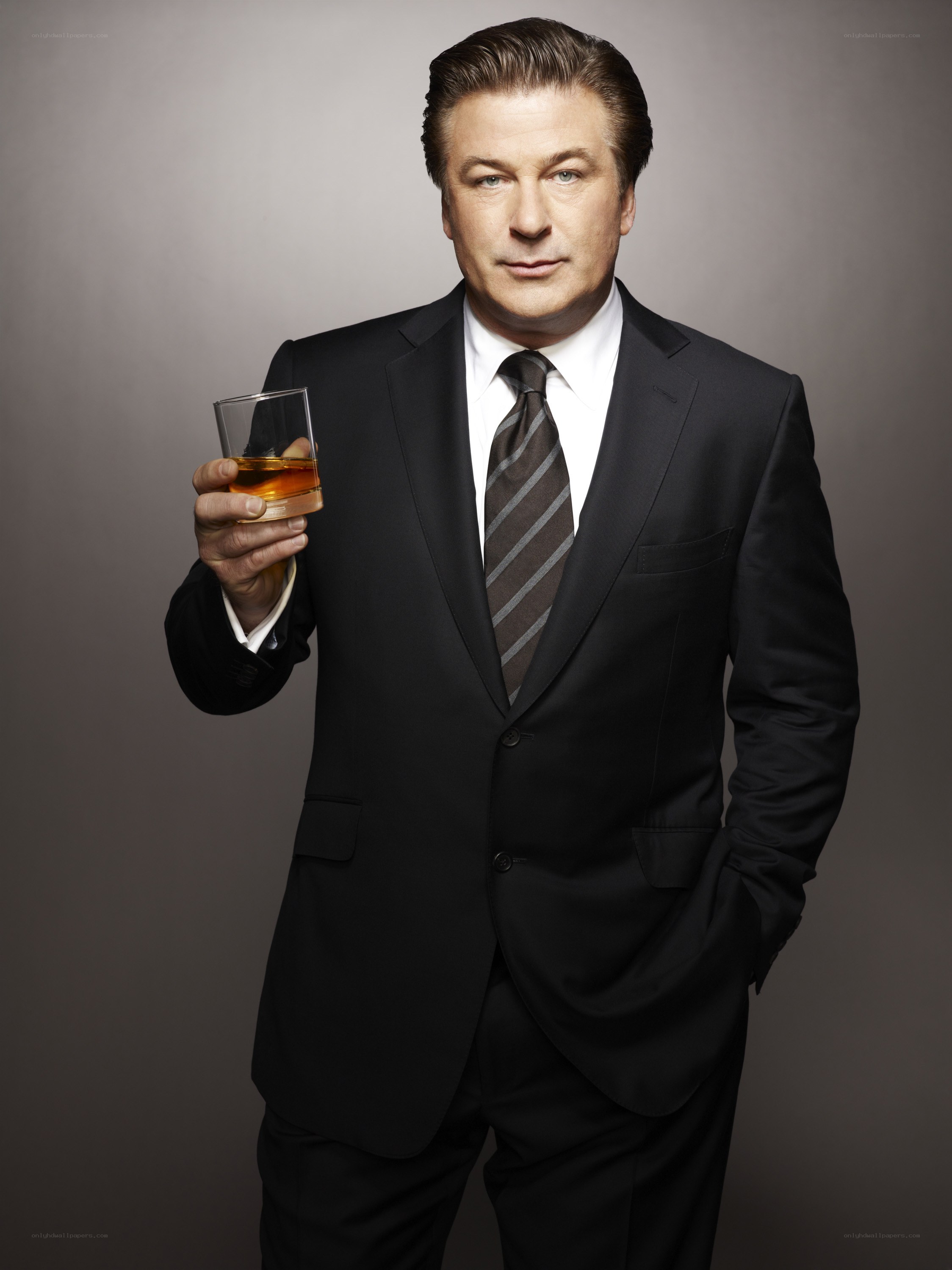 man in suit holding whiskey