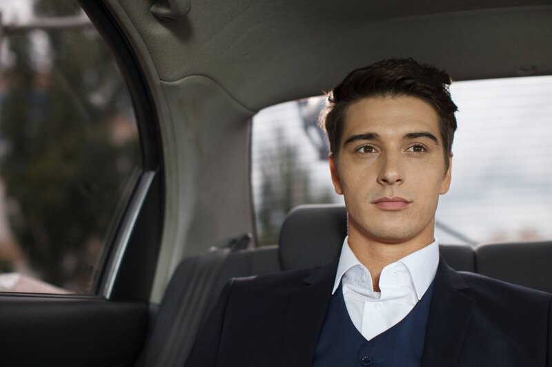 man in suit in car