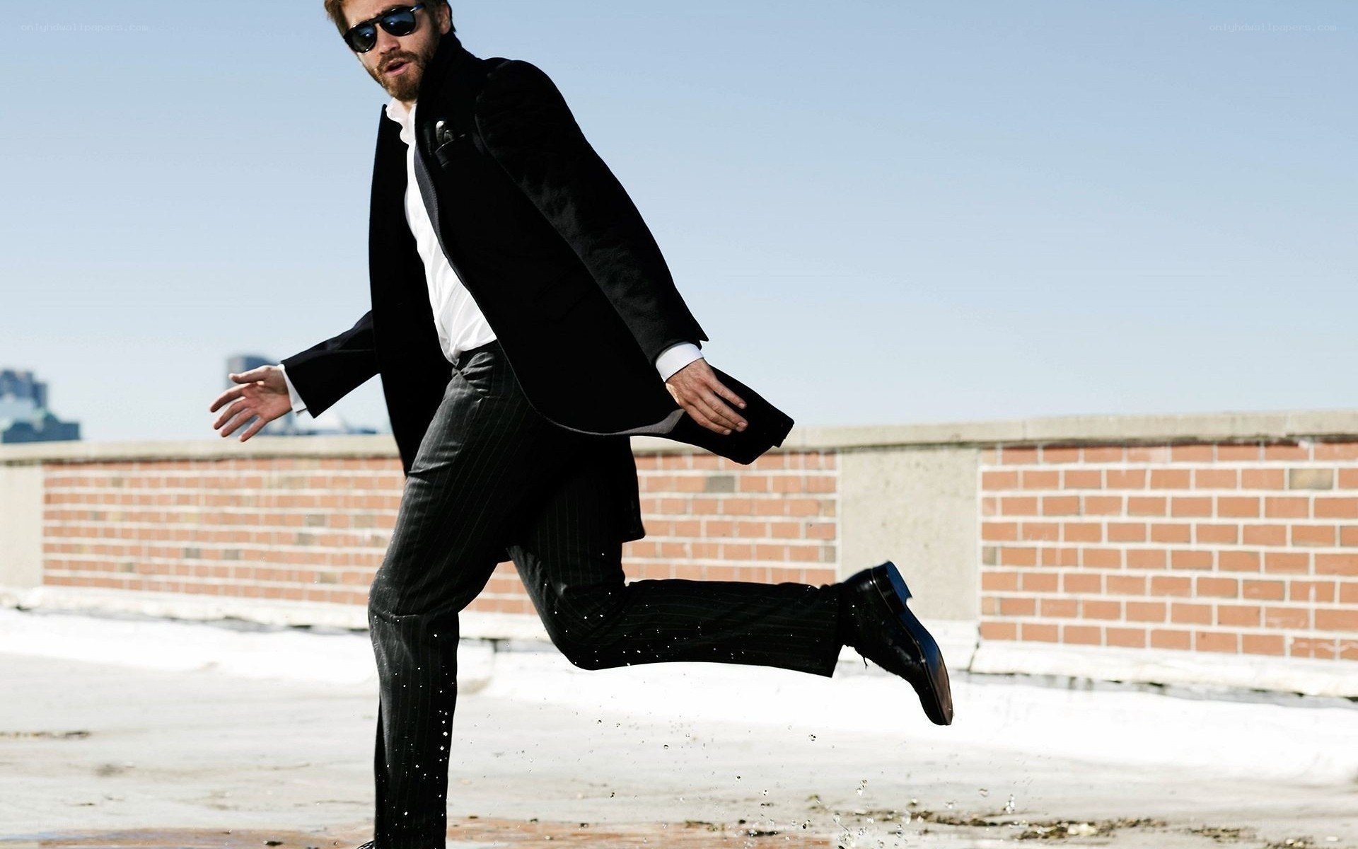 man in suit jumping on rooftop
