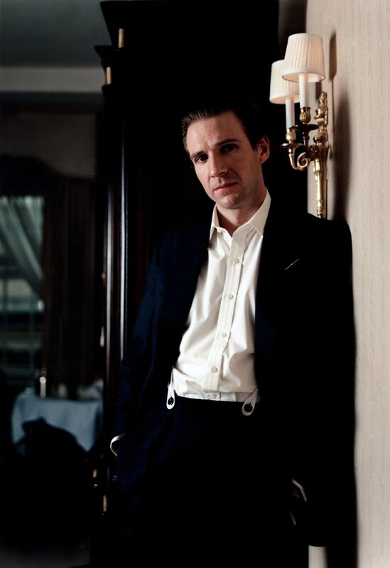 man in suit leaning against wall