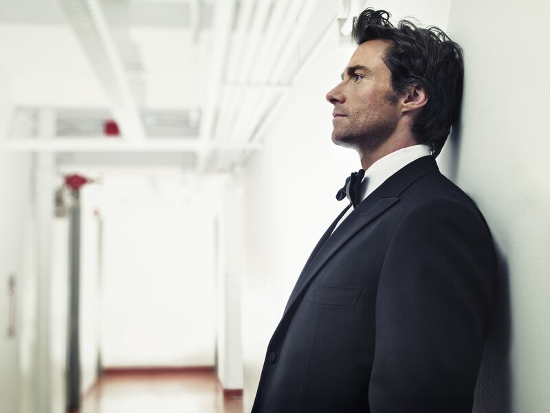 man in suit leaning against wall