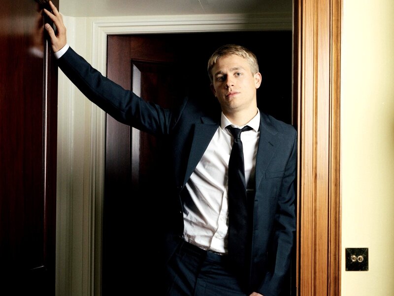 man in suit leaning in doorway