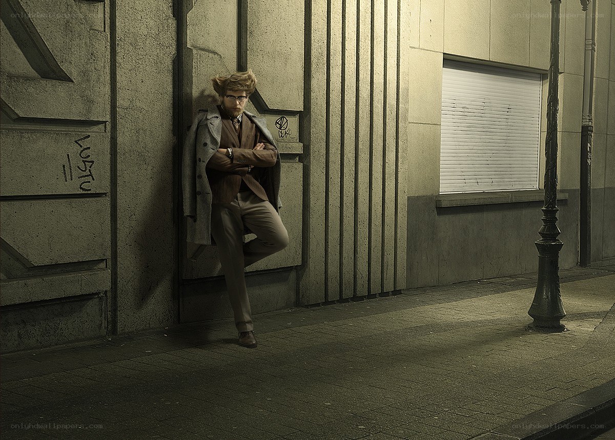 man in suit leaning on wall