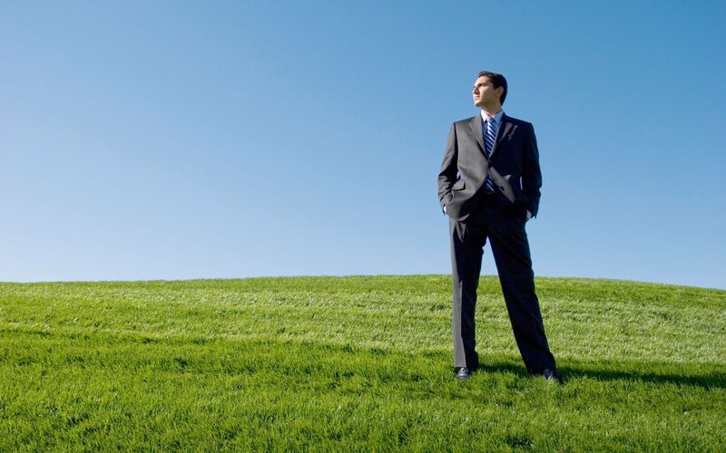 Man in suit on grassy hill