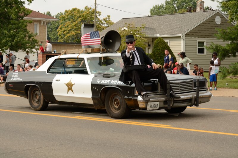Man in Suit on Police Car — Black