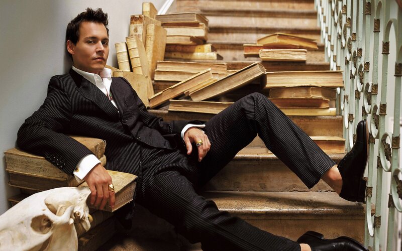 Man in suit on stairs with books