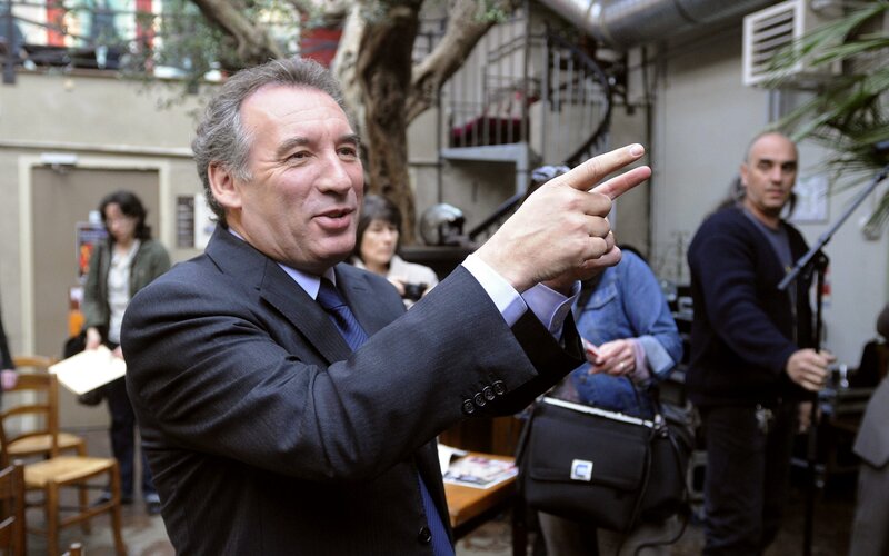 Man in suit pointing at something